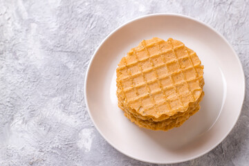 A stack of thin salty waffles on a plate