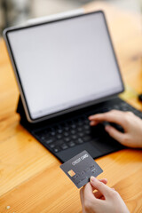 Close up of woman hand holding credit card and using smart phone and tablet for online shopping and payment. Online shopping and payment online concept