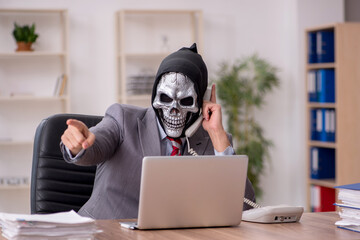 Devil businessman employee sitting at workplace
