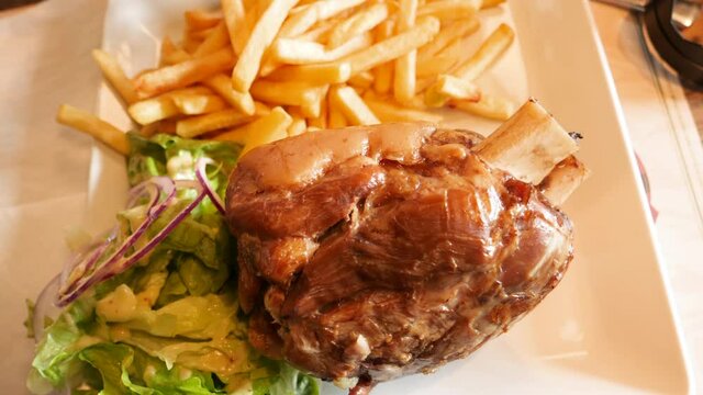Slow pan over the traditional Aslatian German dish Ham hock - pork knuckle is the joint between the tibia fibula and the metatarsals of the foot of a pig, where the foot was attached to the hog's leg