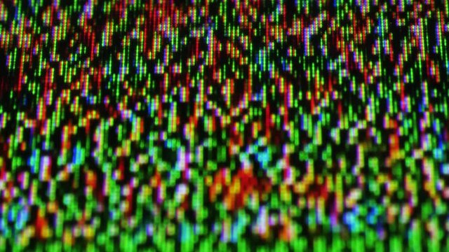 Multiple colorful pixels of a plasma display transmitting bad signal reception - close-up slow defocus