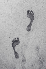 Wet male footprints on concrete surface