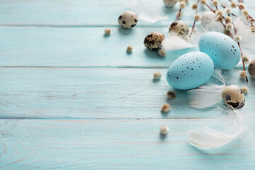 colorful easter eggs and spring flowers on blue wooden background