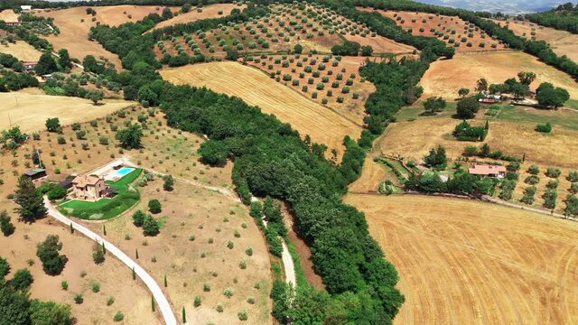 Tuscan countryside shot with drone at summer time. Aerial view of amazing country in sunny weather, arid fields,green trees,olive trees 
