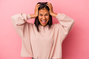 Young latin woman isolated on pink background  screaming, very excited, passionate, satisfied with something.