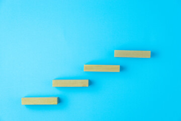 Pyramid of four wooden cubes, on blue background