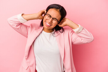 Young latin woman isolated on pink background  covering ears with hands.