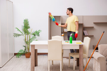 Young male contractor cleaning the house
