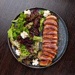 Duck breast with lettuce and cream cheese. On a wooden background