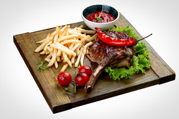 Lamb rack with fries and sauce оn a wooden board. On a white background