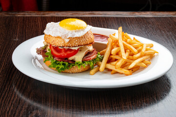 Burger for kids with fries and sauce. On a wooden background