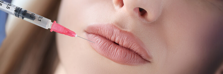 Portrait of woman whose lips are injected by beautician