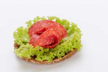 Sandwich with salami sausage on white background.