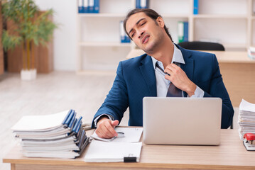 Fototapeta premium Young male employee unhappy with excessive work