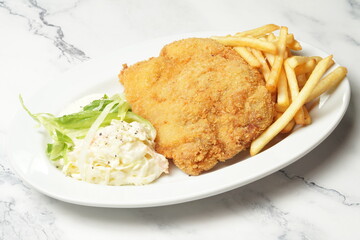 crispy chicken cutlet with fries and salad