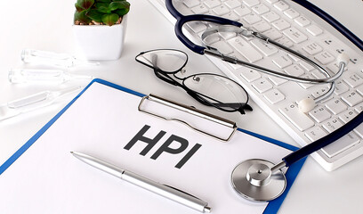 HPI text on white paper on white background. stethoscope ,glasses and keyboard