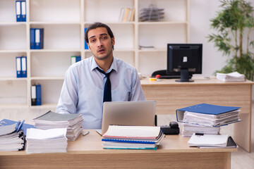 Young male employee and too much work in the office