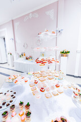 Delicious wedding buffet candy bar, dessert table. Delicious birthday party with cupcakes. Festive decor in the restaurant. Celebrating the anniversary of the date