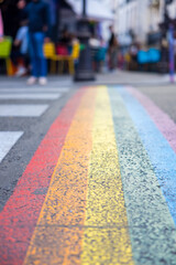 Vertical shot of a street colored with rainbow LGBTQ colors with blurred background