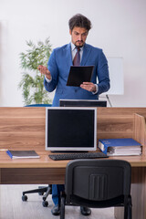 Young male employee sitting at workplace