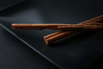 Close up of cinnamon sticks on black background.