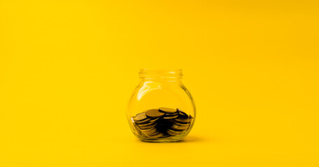 coin in glass bottle to save money financial business investment ideas Copy space for your text. on a yellow background
