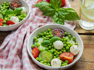 Salad vegetarian. Fresh vegetable salad with tomato, cucumber, basil, green peas, mozzarella cheese.