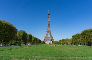 The Eiffel tower from the Champ de Mars, on a sunny day, with the scaffolding of its restoration