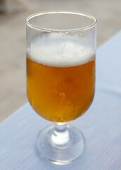 Fresh beer in a glass on the table.