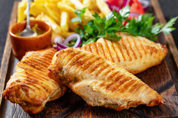 chicken breasts with french fries and salad