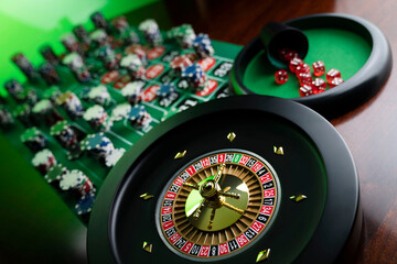 
Casino. Gambling games theme.  Roulette wheel, dice and poker chips on the casino felt green table.
