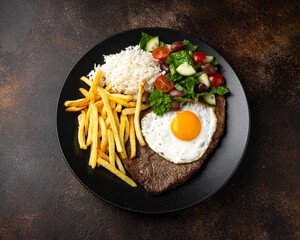 Portugal dish Bitoque made from beef steak with a fried egg, rice, french fries and vegetables