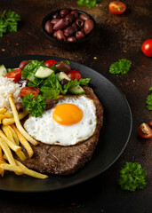 Portugal dish Bitoque made from beef steak with a fried egg, rice, french fries and vegetables