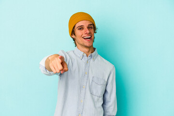 Young caucasian man with make up isolated on blue background  cheerful smiles pointing to front.