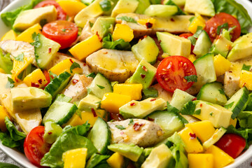 Tasty Chicken mango salad with avocado, cucumber, cherry tomatoes. Healthy food