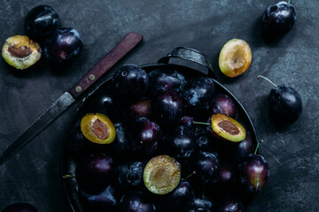Ripe blue plums on a dark background