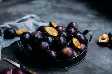 Ripe blue plums on a dark background
