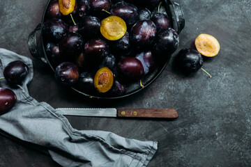 Ripe blue plums on a dark background