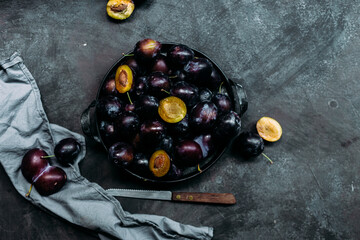 Ripe blue plums on a dark background