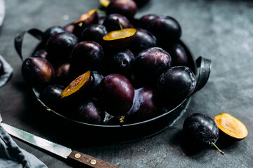 Ripe blue plums on a dark background