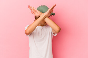 Young caucasian man with make up isolated on pink background keeping two arms crossed, denial concept.