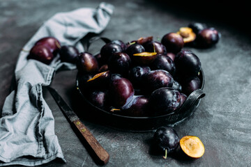 Ripe blue plums on a dark background