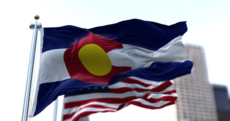 the flag of the US state of Colorado waving in the wind with the American stars and stripes flag...