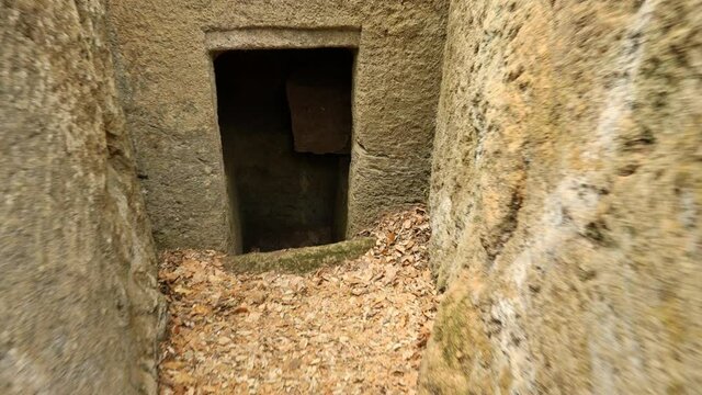Walking through POV entering an Etruscan tomb. Etruscan tomb chamber in the Archaeological Park of Baratti and Populonia, Tuscany, Italy.