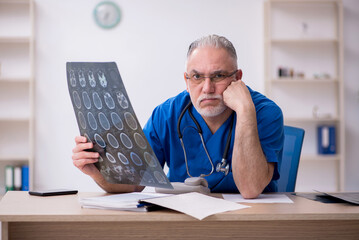 Old male doctor radiologist working in the clinic