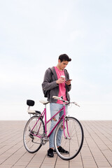 Obraz premium young man with bicycle and coffee using phone