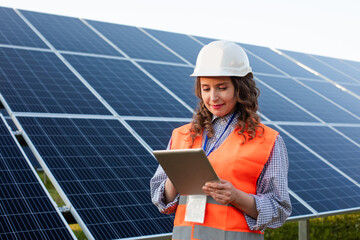 Female engineer is working with tablet at solar station - 456702438