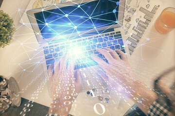Multi exposure of man's hands typing over computer keyboard and data theme hologram drawing. Top view. Technology concept.