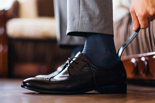 male hands and a pair of leather shoes. morning of business people. the groom gets dressed in the hotel room
