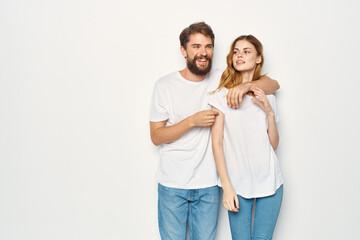 man and woman in white t-shirts are standing next to family light background